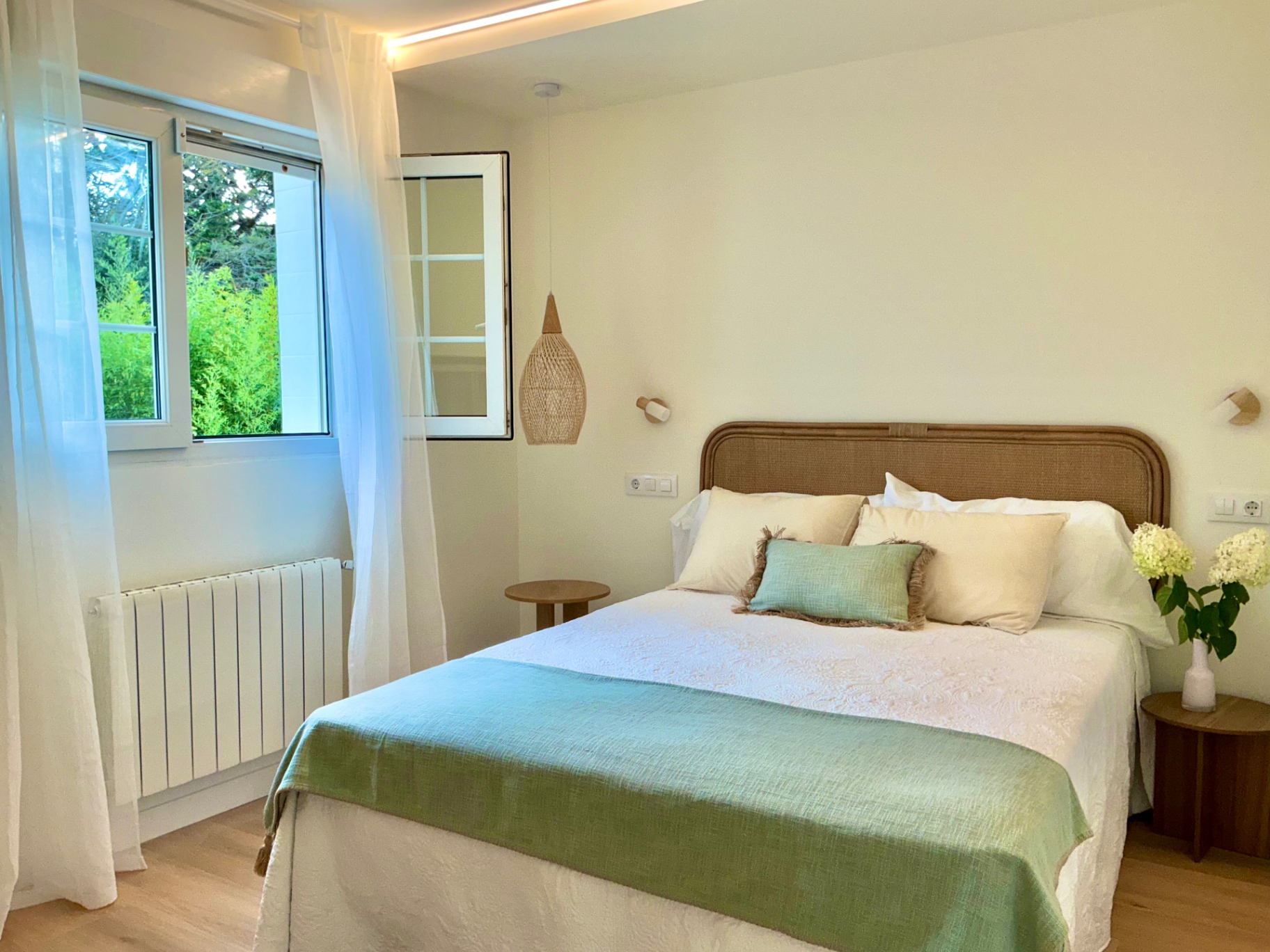 Dormitorio con cama doble y vistas al verde