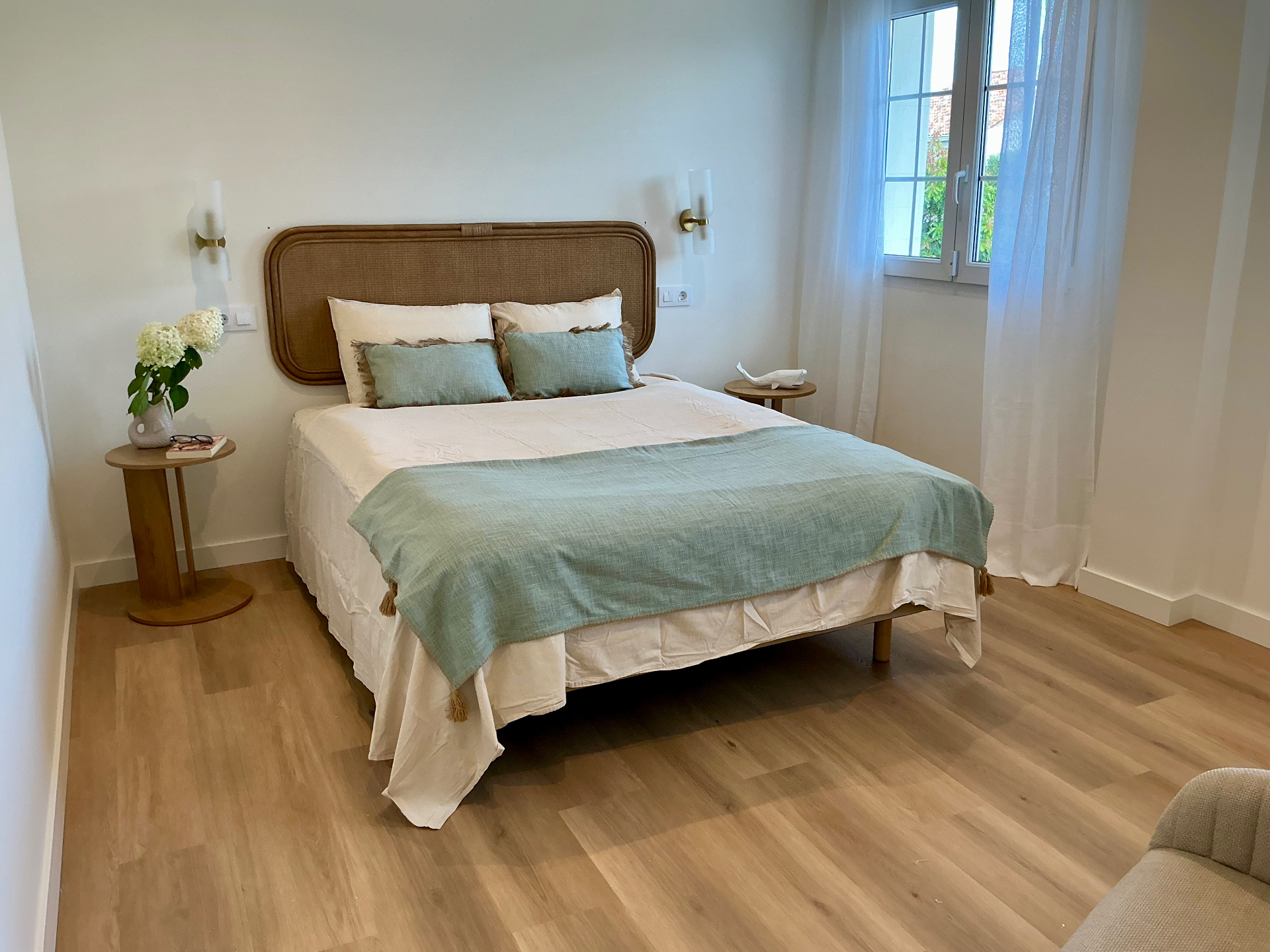 Dormitorio con cama doble y cabecero de ratán