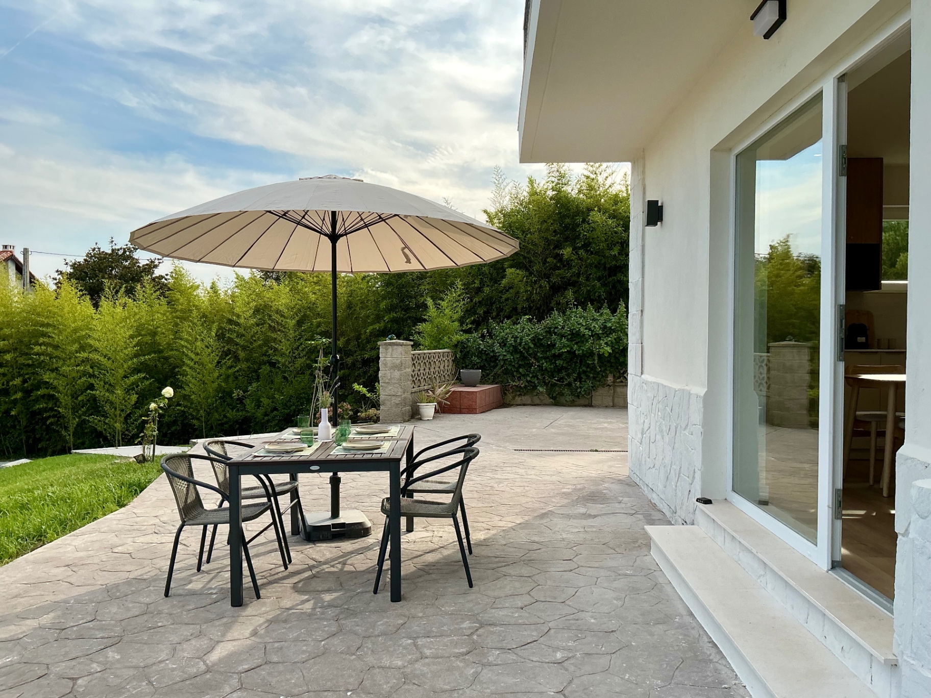 Terraza exterior con mesa, sillas y parasol