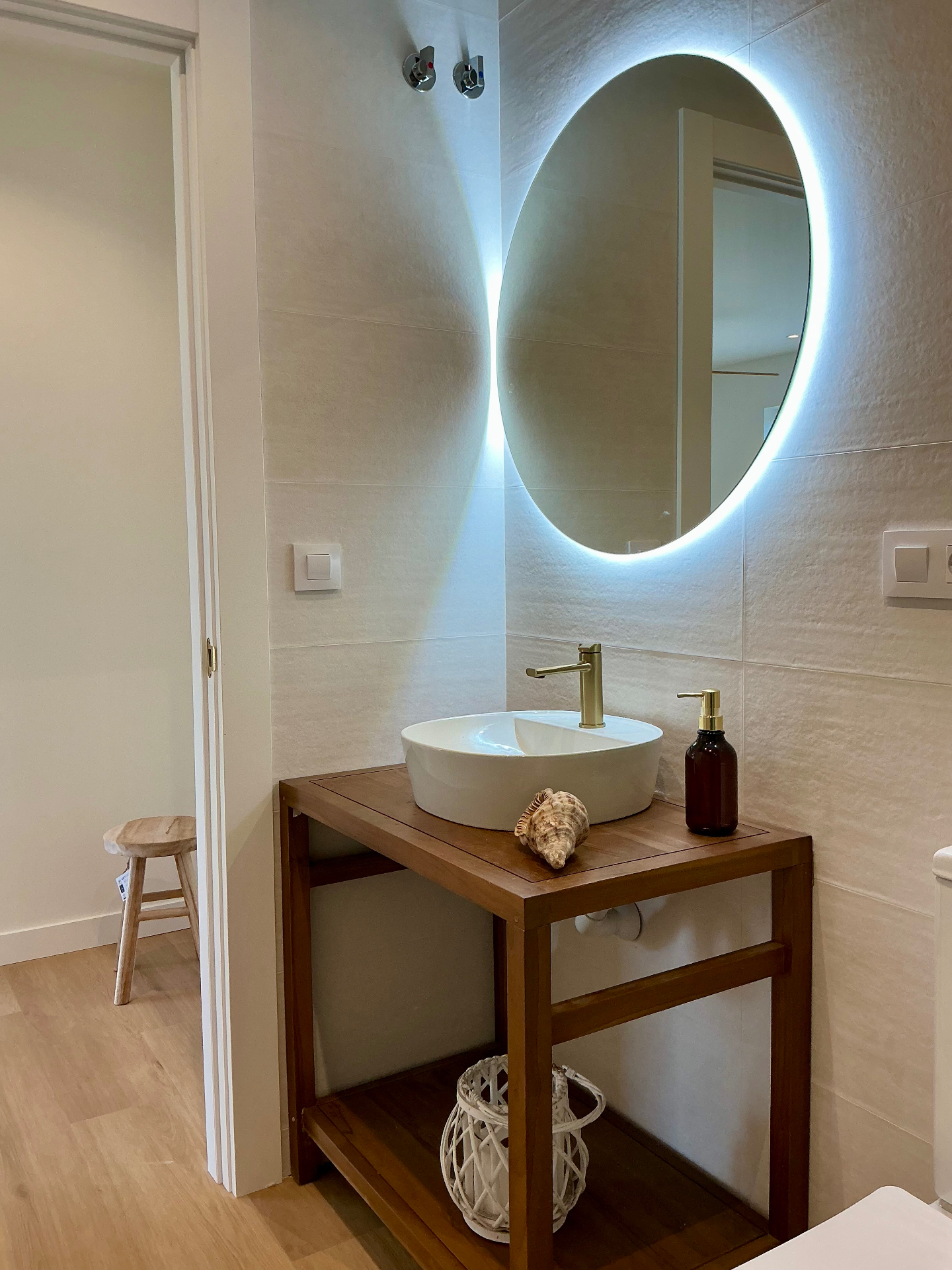 Lavabo de baño con espejo circular retroiluminado